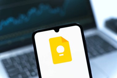 Prag, Çek Cumhuriyeti - 08 12 2025: Bir dizüstü bilgisayarın önünde duran bir cep telefonu Google Keep logosunu gösteriyor. Google Keep notlar, listeler ve hatırlatıcılar için bir platformdur.