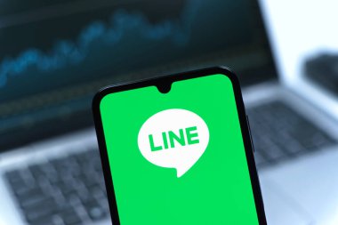 Prag, Çek Cumhuriyeti - 08 12 2025: Dizüstü bilgisayarın önünde duran bir cep telefonu Line logosunu gösteriyor. Line aramalar, mesajlar ve çokluortam paylaşımı için bir mesajlaşma uygulamasıdır.