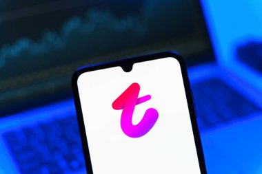 Prag, Çek Cumhuriyeti - 08 12 2025: Bilgisayarın önünde duran bir cep telefonu Tango logosunu gösteriyor. Tango, görüntülü aramalar, mesajlar ve canlı yayınlar için sosyal bir uygulama..