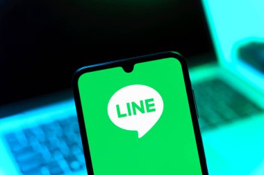 Prag, Çek Cumhuriyeti - 08 12 2025: Dizüstü bilgisayarın önünde duran bir cep telefonu Line logosunu gösteriyor. Line aramalar, mesajlar ve çokluortam paylaşımı için bir mesajlaşma uygulamasıdır.