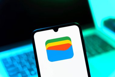 Prag, Çek Cumhuriyeti - 08 12 2025: Bir dizüstü bilgisayarın önünde duran bir cep telefonu Google Cüzdan logosunu gösteriyor. Google Cüzdanı dijital ödeme yöntemlerini depolamak ve kullanmak için bir platformdur.