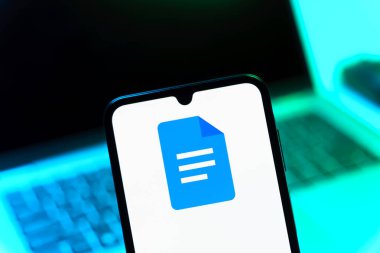 Prag, Çek Cumhuriyeti - 08 12 2025: Bilgisayarın önünde duran bir cep telefonu Google Docs logosunu görüntüler. Google Docs metin belgeleri oluşturmak ve düzenlemek için bir platformdur.