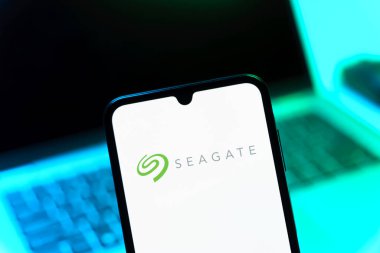 Prag, Çek Cumhuriyeti - 08 12 2025: Bir dizüstü bilgisayarın önünde duran bir cep telefonu Seagate logosunu gösteriyor. Seagate sabit disk ve depolama çözümleri üreten bir şirkettir..