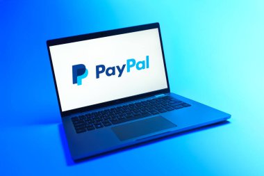 Prague, Czechia - 08 12 2025: A dynamic view of a laptop on a uniform background displaying the PayPal logo. PayPal is a platform for online payments and money transfers.