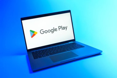 Prague, Czechia - 08 12 2025: A dynamic view of a laptop on a uniform background displaying the Google Play logo. Google Play is a platform for downloading apps, games, and digital content.