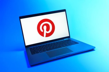 Prague, Czechia - 08 12 2025: A dynamic view of a laptop on a uniform background displaying the Pinterest logo. Pinterest is a platform for discovering and saving ideas visually.