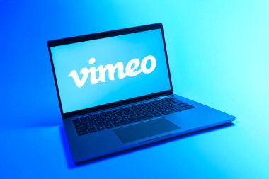 Prague, Czechia - 08 12 2025: A dynamic view of a laptop on a uniform background displaying the Vimeo logo. Vimeo is a platform for hosting and sharing high-quality videos.