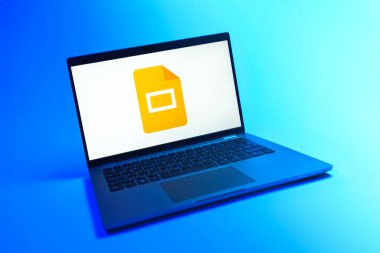 Prague, Czechia - 08 12 2025: A dynamic view of a laptop on a uniform background displaying the Google Slides logo. Google Slides is a platform for creating presentations and slideshows.