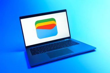 Prague, Czechia - 08 12 2025: A dynamic view of a laptop on a uniform background displaying the Google Wallet logo. Google Wallet is a platform for storing and using digital payment methods.