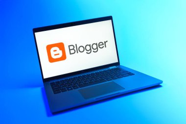 Prague, Czechia - 08 12 2025: A dynamic view of a laptop on a uniform background displaying the Blogger logo. Blogger is a platform for creating and publishing blogs.