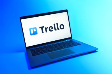 Prague, Czechia - 08 12 2025: A dynamic view of a laptop on a uniform background displaying the Trello logo. Trello is a platform for project management using boards and tasks.