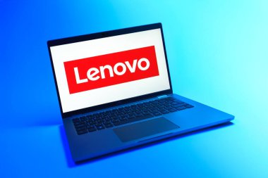 Prague, Czechia - 08 12 2025: A dynamic view of a laptop on a uniform background displaying the Lenovo logo. Lenovo is a technology company producing computers and electronics.