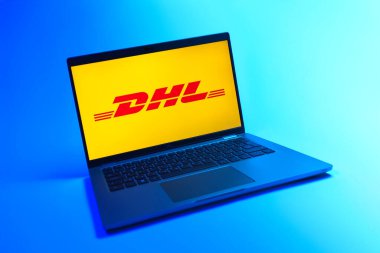 Prague, Czechia - 08 12 2025: A dynamic view of a laptop on a uniform background displaying the DHL logo. DHL is a logistics company offering international shipping services.