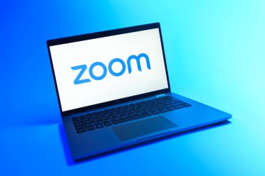 Prague, Czechia - 08 12 2025: A dynamic view of a laptop on a uniform background displaying the Zoom logo. Zoom is a platform for video meetings and online collaboration.