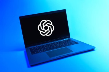 Prague, Czechia - 08 12 2025: A dynamic view of a laptop on a uniform background displaying the OpenAI logo. OpenAI is a platform developing AI models and applications.