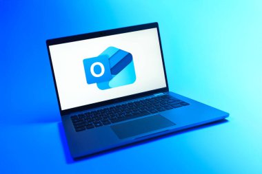 Prag, Çek Cumhuriyeti - 08 12 2025: Outlook logosunu gösteren tek bir arkaplanda dinamik bir dizüstü bilgisayar görüntüsü. Outlook iletileri göndermek ve yönetmek için bir e- posta platformudur.