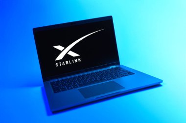 Prague, Czechia - 08 12 2025: A dynamic view of a laptop on a uniform background displaying the Starlink logo. Starlink is a satellite internet service providing global connectivity.