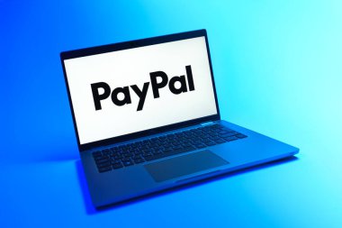 Prague, Czechia - 08 12 2025: A dynamic view of a laptop on a uniform background displaying the PayPal logo. PayPal is a platform for online payments and money transfers.