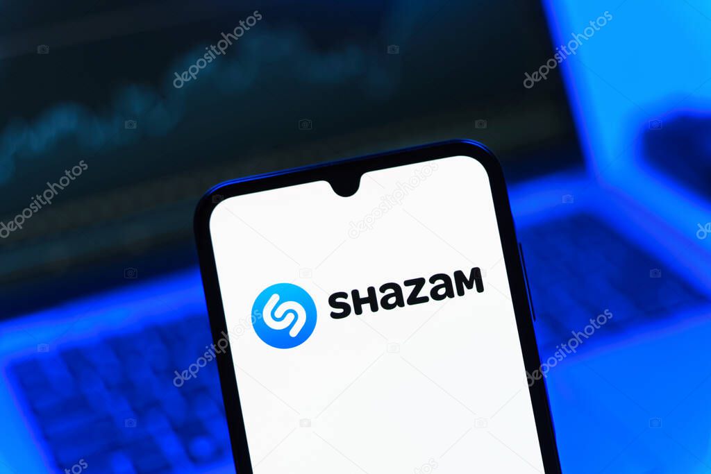 Prague, Czechia - 08 12 2025: A mobile phone standing in front of a laptop displays the Shazam logo. Shazam is an app for identifying songs and music tracks.