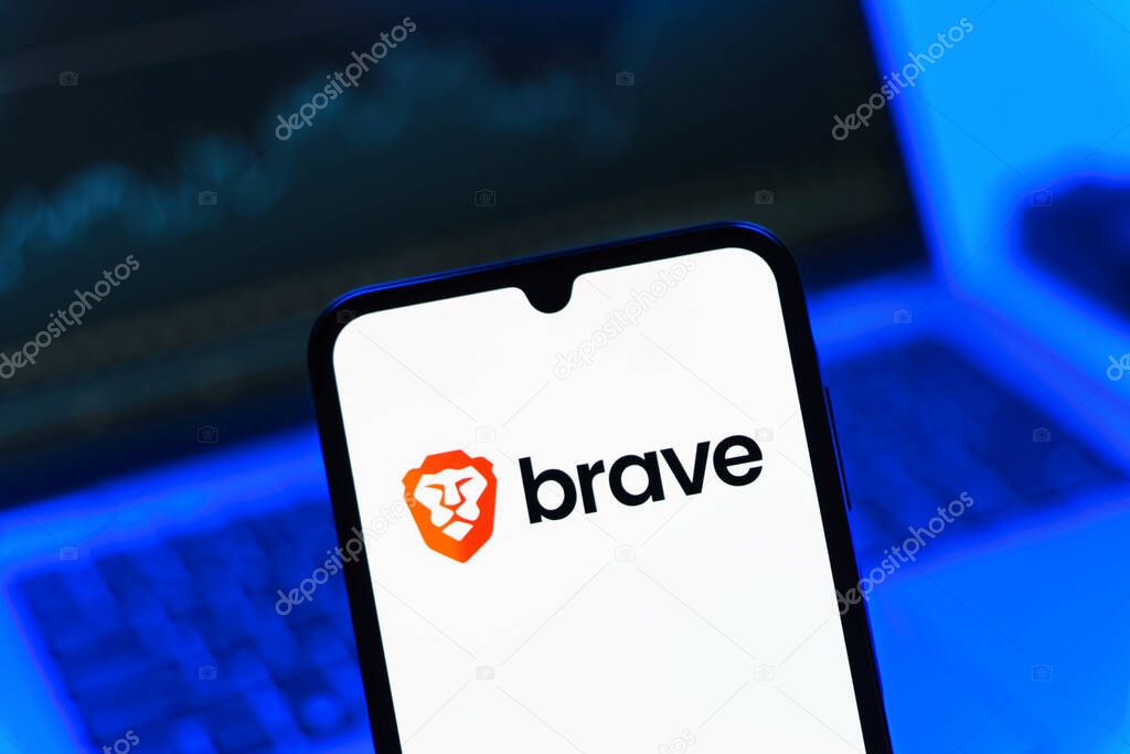 Prague, Czechia - 08 12 2025: A mobile phone standing in front of a laptop displays the Brave logo. Brave is a web browser focused on privacy and speed.