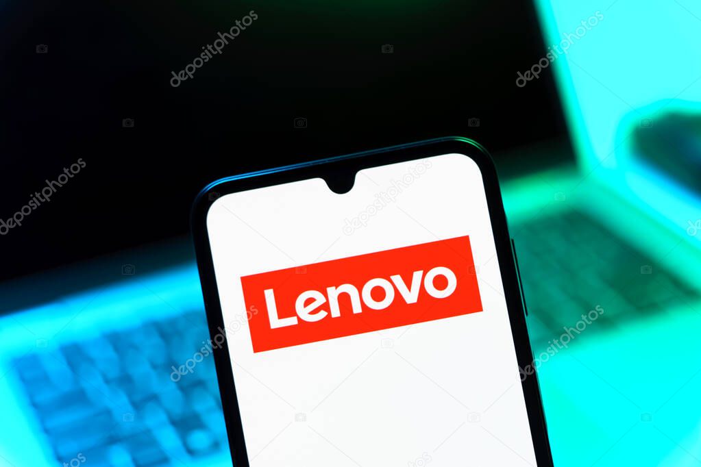 Prague, Czechia - 08 12 2025: A mobile phone standing in front of a laptop displays the Lenovo logo. Lenovo is a technology company producing computers and electronics.
