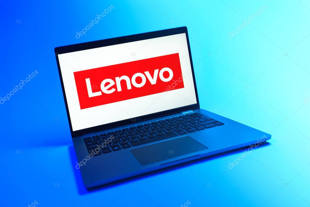 Prague, Czechia - 08 12 2025: A dynamic view of a laptop on a uniform background displaying the Lenovo logo. Lenovo is a technology company producing computers and electronics.
