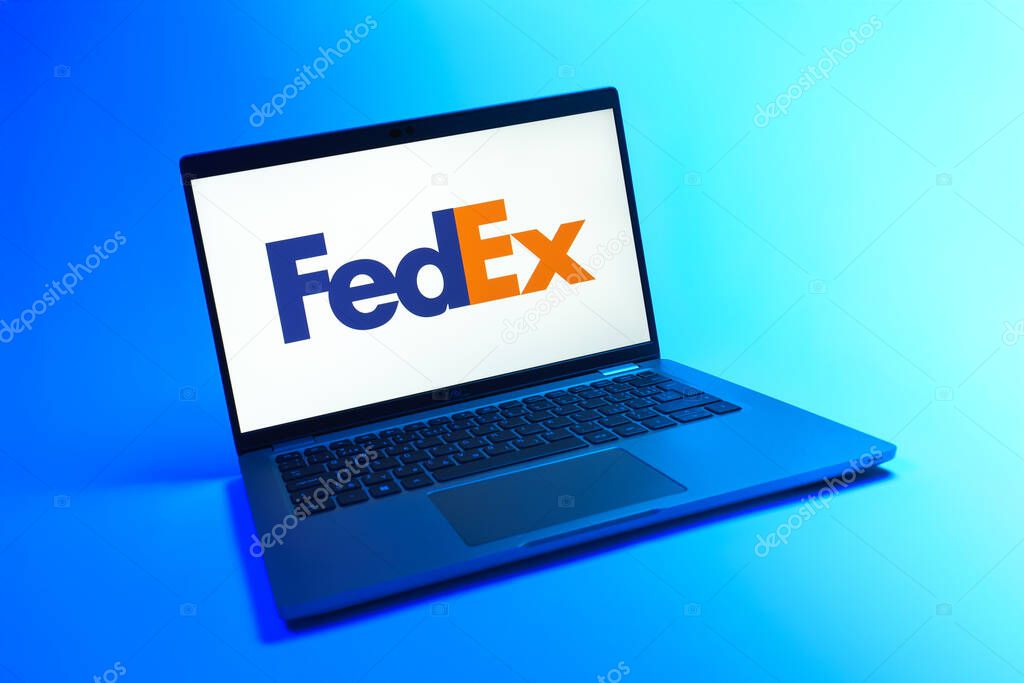 Prague, Czechia - 08 12 2025: A dynamic view of a laptop on a uniform background displaying the FedEX logo. FedEX is a logistics company providing shipping and courier services.