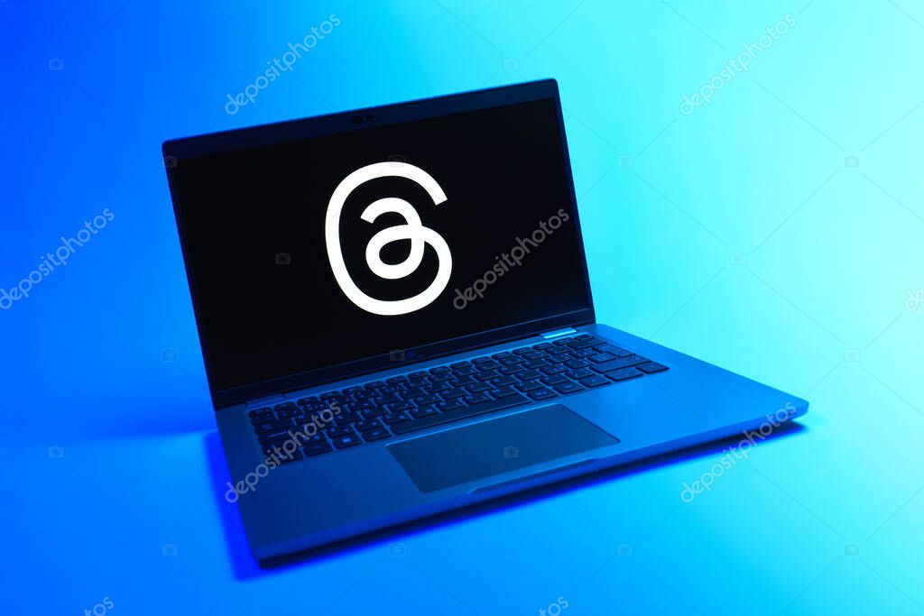 Prague, Czechia - 08 12 2025: A dynamic view of a laptop on a uniform background displaying the Threads logo. Threads is a social media platform for sharing short posts and updates.