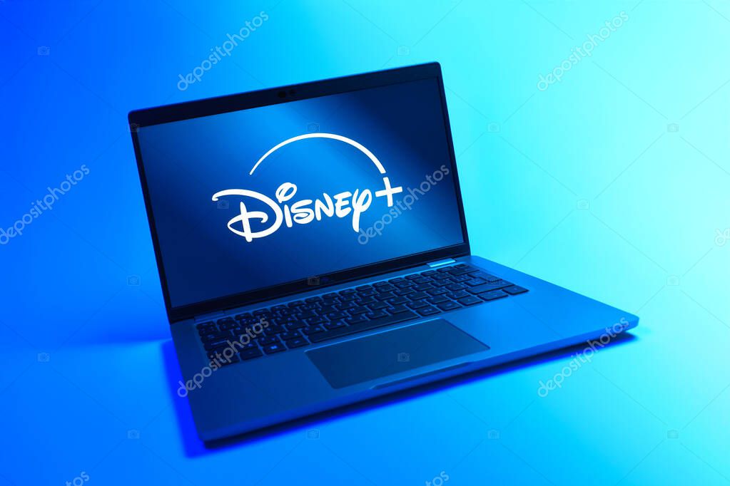 Prague, Czechia - 08 12 2025: A dynamic view of a laptop on a uniform background displaying the Disney+ logo. Disney + is a streaming platform for movies and TV shows.