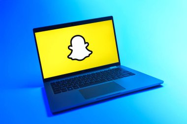 Prague, Czechia - 08 12 2025: A dynamic view of a laptop on a uniform background displaying the Snapchat logo. Snapchat is an app for sending photos, videos, and temporary messages.