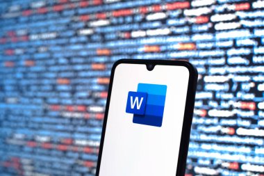 Prague, Czechia - 08 12 2025: Phone in front of a screen showing the Word logo. Word is a software for creating and editing documents.