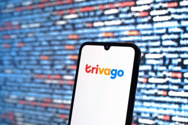 Prague, Czechia - 08 12 2025: Phone in front of a screen showing the Trivago logo. Trivago is a platform for comparing hotel prices and deals.
