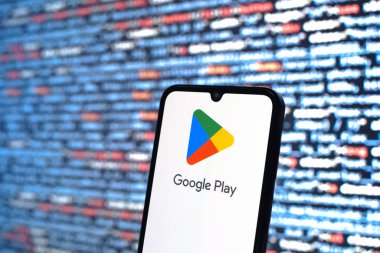 Prague, Czechia - 08 12 2025: Phone in front of a screen showing the Google Play logo. Google Play is a platform for downloading apps, games, and digital content.