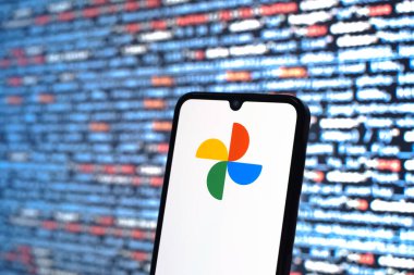 Prague, Czechia - 08 12 2025: Phone in front of a screen showing the Google Photos logo. Google Photos is a platform for storing and organizing photos and videos.