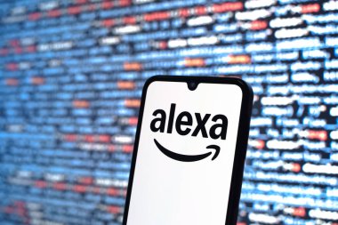 Prague, Czechia - 08 12 2025: Phone in front of a screen showing the Alexa logo. Alexa is a voice assistant for smart devices and services.