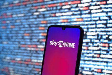 Prague, Czechia - 08 12 2025: Phone in front of a screen showing the SkyShowtime logo. SkyShowtime is a streaming platform for movies and TV series.