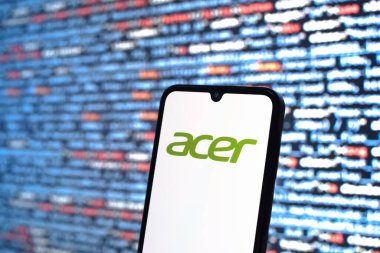 Prague, Czechia - 08 12 2025: Phone in front of a screen showing the Acer logo. Acer is a technology company making computers and electronics.