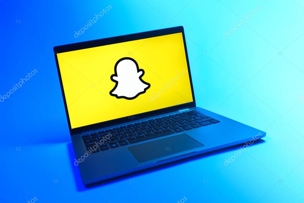 Prague, Czechia - 08 12 2025: A dynamic view of a laptop on a uniform background displaying the Snapchat logo. Snapchat is an app for sending photos, videos, and temporary messages.
