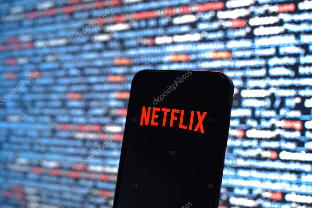 Prague, Czechia - 08 12 2025: Phone in front of a screen showing the Netflix logo. Netflix is a streaming platform for movies and TV shows.