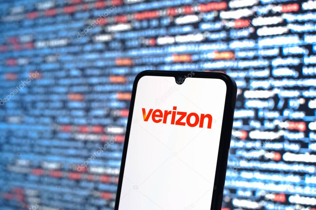 Prague, Czechia - 08 12 2025: Phone in front of a screen showing the Verizon logo. Verizon is a telecom company providing wireless and broadband services.