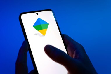 Prag, Çek Cumhuriyeti - 08 12 2025: Mavi arkaplandaki eller Google Family Link logosunu gösteren bir cep telefonu tutuyor. Google Family Link ebeveyn denetimi ve çocuk hesabı yönetimi için bir platformdur.