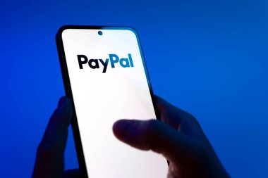 Prag, Çek Cumhuriyeti - 08 12 2025: Eller mavi arkaplanda Discord logosunu gösteren bir cep telefonu tutuyor. Discord ses, video ve metin iletişimi için bir platformdur..