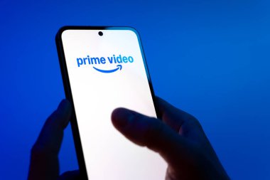 Prag, Çek Cumhuriyeti - 08 12 2025: Eller mavi arkaplanda Discord logosunu gösteren bir cep telefonu tutuyor. Discord ses, video ve metin iletişimi için bir platformdur..