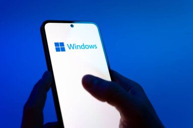 Prag, Çek Cumhuriyeti - 08 12 2025: Eller mavi arkaplanda Discord logosunu gösteren bir cep telefonu tutuyor. Discord ses, video ve metin iletişimi için bir platformdur..