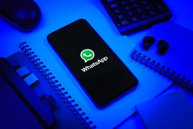 Prag, Çek Cumhuriyeti - 08 18 2025: Ofis malzemelerinin merkezde WhatsApp logosunu gösteren bir cep telefonu ile düzenlenmesi. WhatsApp mesaj, çağrı ve medya göndermek için bir uygulamadır.