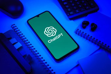 Prag, Çek Cumhuriyeti - 08 18 2025: Merkezinde ChatGPT logosu bulunan bir cep telefonu ile ofis malzemeleri düzenlemesi. ChatGPT metin üretmek ve soruları cevaplamak için bir yapay zeka sohbet robotudur..