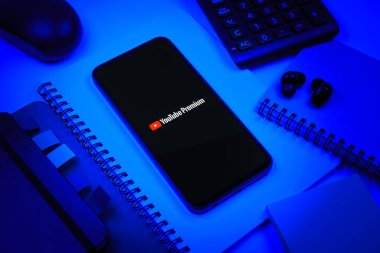 Prag, Çek Cumhuriyeti - 08 18 2025: Merkezinde Youtube Premium logosu bulunan bir cep telefonu ile ofis malzemeleri düzenlemesi. Youtube Premium, reklamsız videolar ve çevrimdışı oynatma için bir aboneliktir.