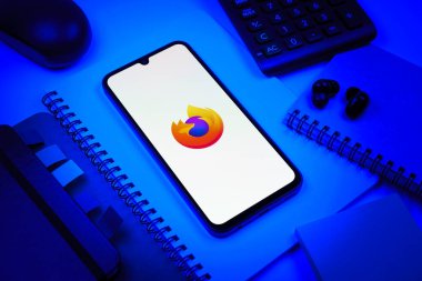 Prag, Çek Cumhuriyeti - 08 18 2025: Merkezde Firefox logosunu gösteren bir cep telefonu ile ofis malzemeleri düzenlemesi. Firefox hızlı ve güvenli internet taraması için bir web tarayıcısıdır.