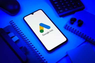 Prag, Çek Cumhuriyeti - 08 18 2025: Merkezde Google Ads logosunu gösteren bir cep telefonu ile ofis malzemeleri düzenlemesi. Google Reklamları, çevrimiçi reklamlar yaratmak ve yönetmek için bir platformdur.
