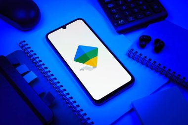 Prag, Çek Cumhuriyeti - 08 18 2025: Merkezde Google Family Link logosunu gösteren bir cep telefonu ile ofis malzemeleri düzenlemesi. Google Family Link ebeveyn denetimi ve çocuk hesabı yönetimi için bir platformdur.